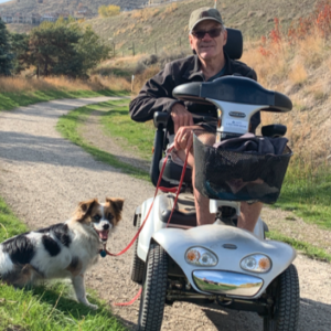 Age and dementia friendly community - man on scooter with dog