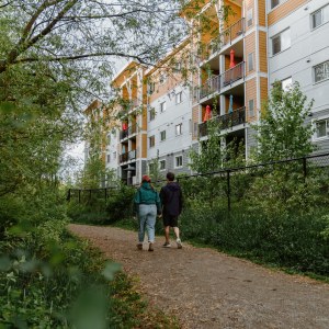 Two people walking on a trail next to a housing development